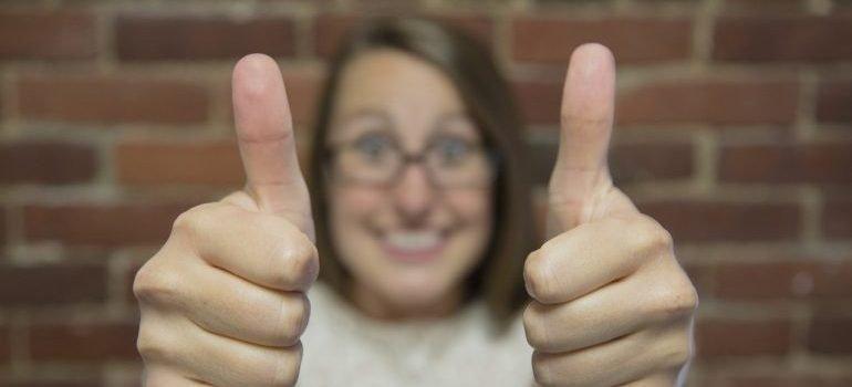 a happy woman holding thumbs up after moving with the long distance movers Florida offers 