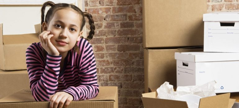 Girl with moving box, representing what to unpack first