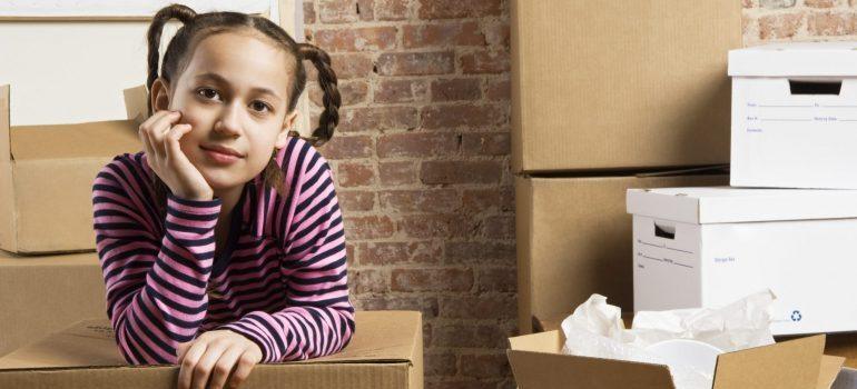 De niña con caja de mudanza, y representa lo que descomprimir primero