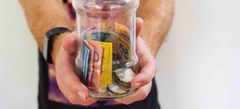 person holding a jar of money