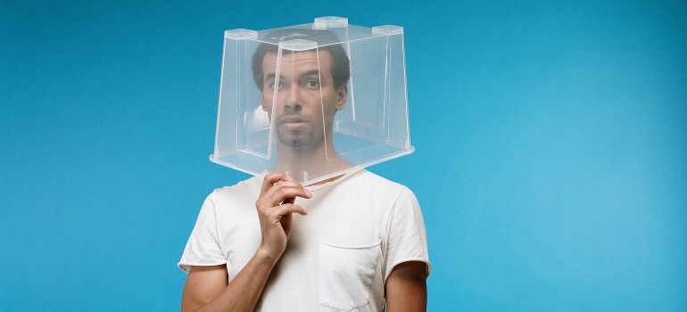 Un hombre con una caja de plástico en la cabeza