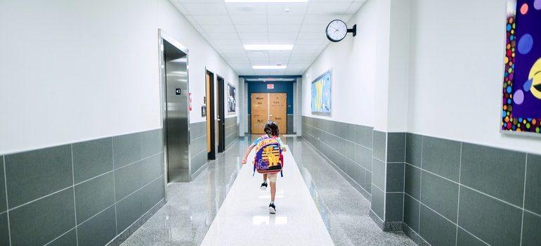 Niño ejecuta a través de un hall de la escuela como resultado de los padres que pensaban acerca de cosas que debe saber antes de mudarse a la Isla Larga.