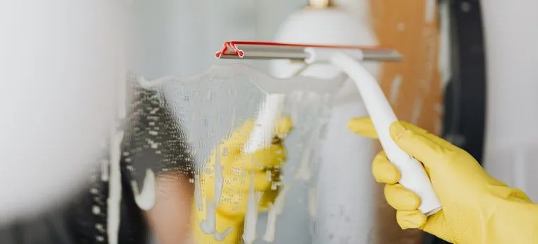 Person cleaning a mirror.