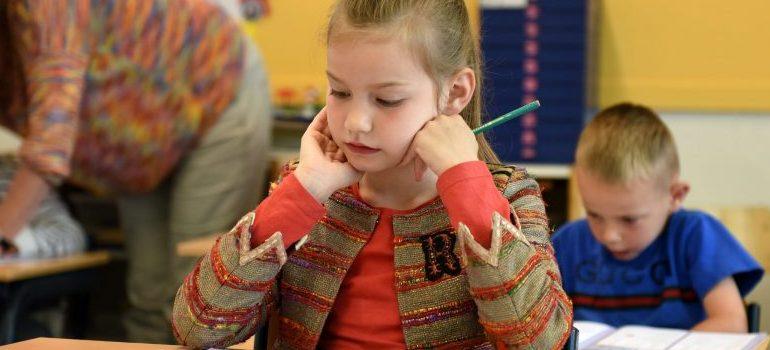 A little girl at school, reading.