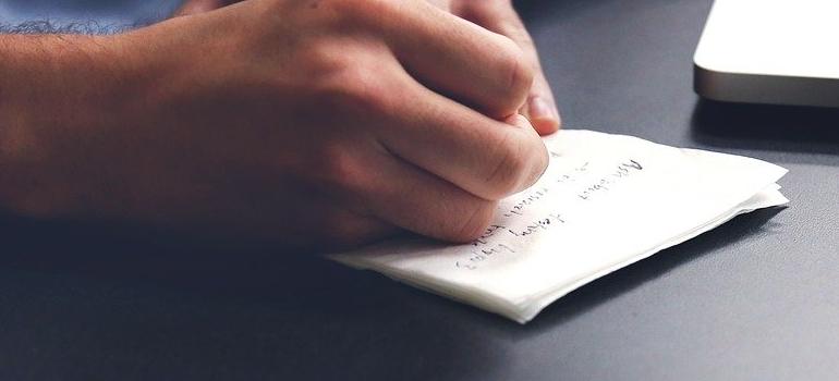 Man writing a plan to handle a quick relocation to Brooklyn.