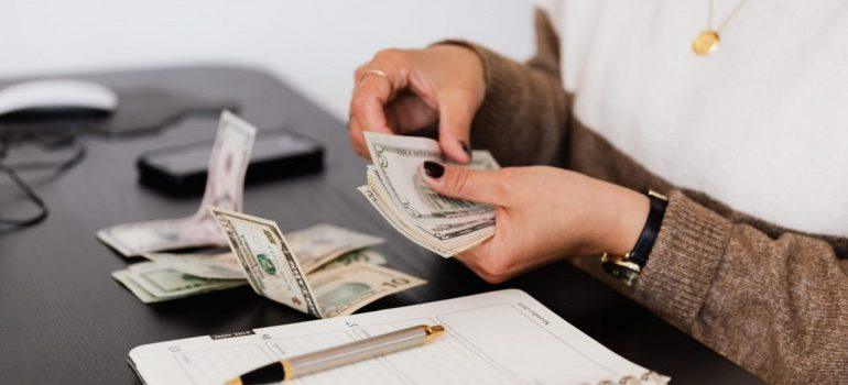 Woman counting money before moving from Dallas to Los Angeles