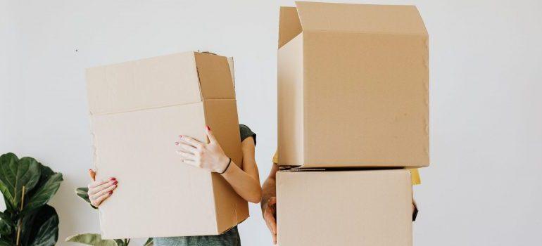 couple-carrying-cardboard-boxes-in-living-room