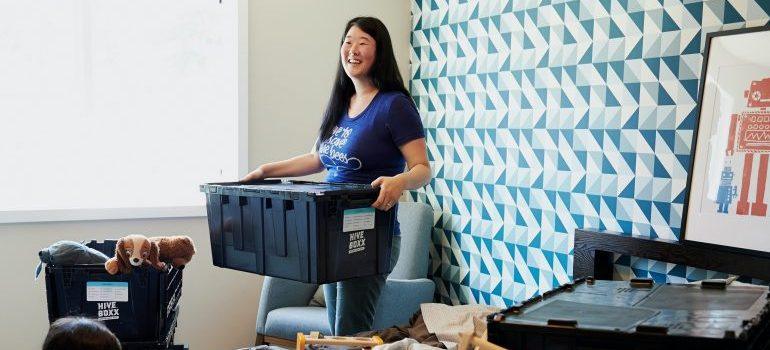 woman carrying a plastic tub