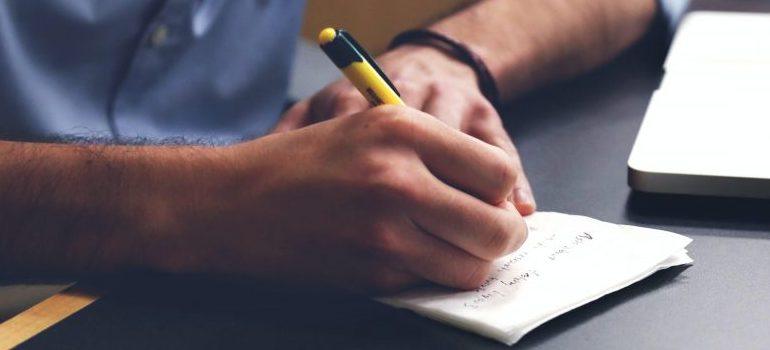 man writing on a paper