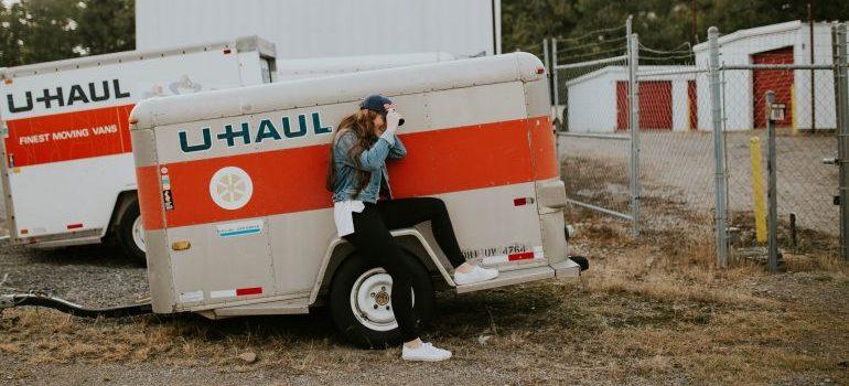 woman sitting on a u-haul mobile storage trailer