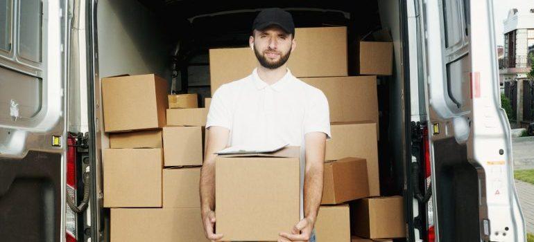 a man holding a box before moving from Texas to NYC