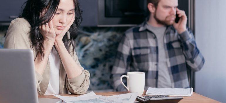 man and woman preparing moving budget