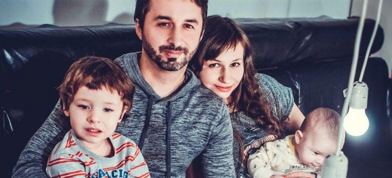 a couple with two kids sitting on a sofa