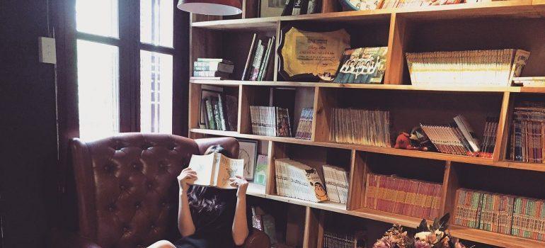 Women reading in library. Pack your book collection shelf by shelf