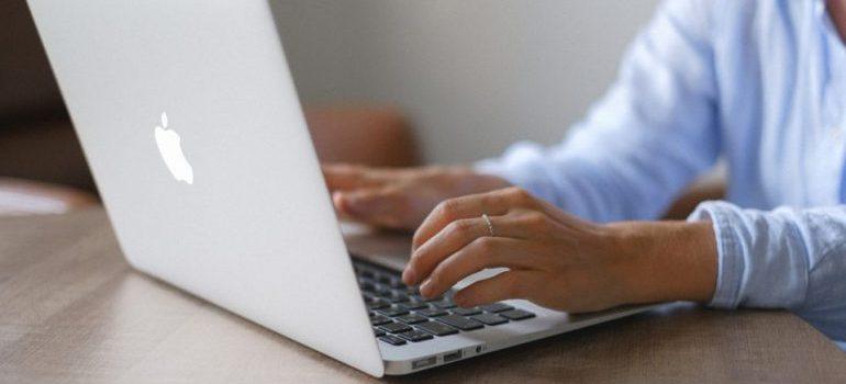 una mujer escribiendo algo en un ordenador portátil