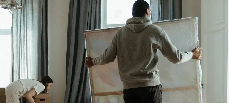 Proteger sus pinturas de los envuelve en plástico de burbujas como la pintura, el hombre que lleva en la foto está envuelto