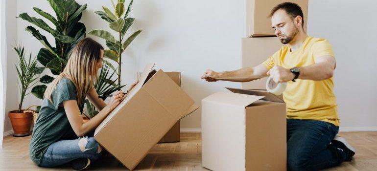 prepare well to relocate your Brooklyn condo like the woman labeling a box while a man is sealing the box with a tape 