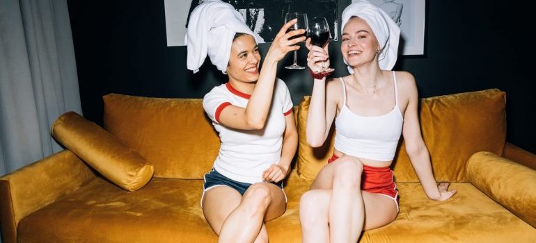Two girls drinking wine on the couch
