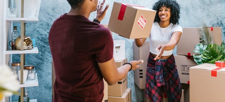 the woodlands long distance movers helping woman pack the boxes