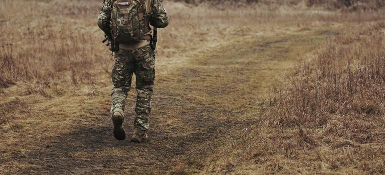 a soldier carrying his backpack