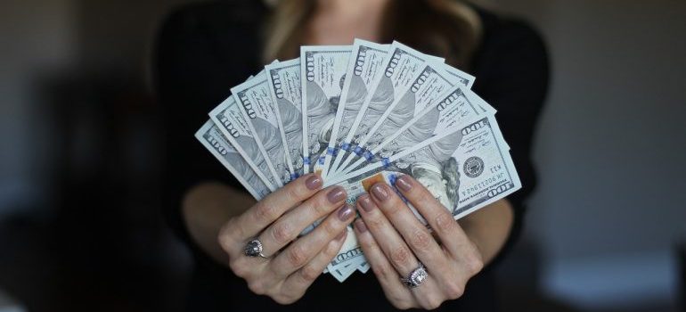 A woman holding a bunch of dollar bills. 