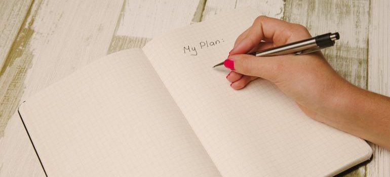 A woman writing down a plan in a notebook.