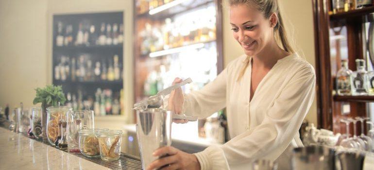 una mujer barman preparando cócteles en un bar