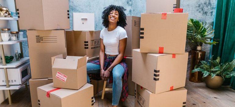 a woman sitting among boxes prepared for loading