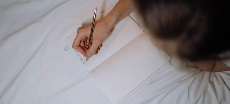 una mujer escribiendo algo en su cuaderno