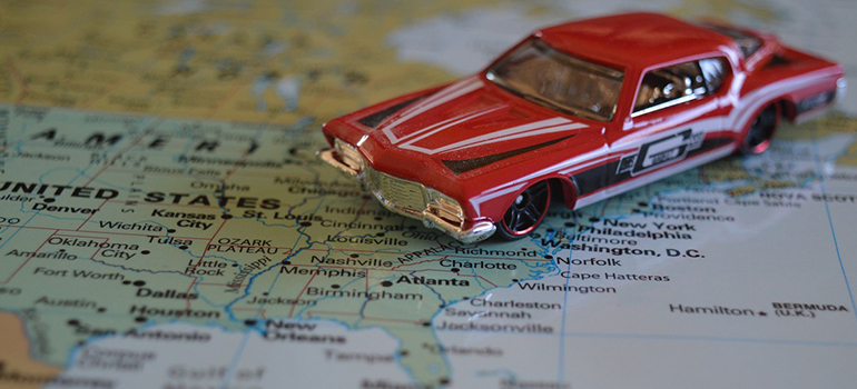 a toy car on a map moving from Texas to Georgia