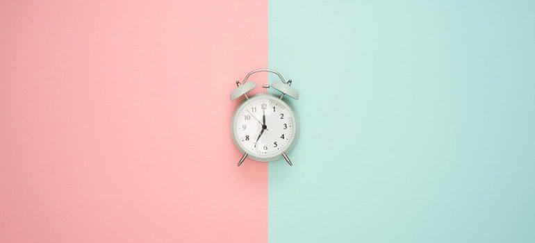 A clock on a pink and blue surface