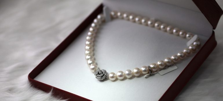 An open box with a pearl neckless inside. 