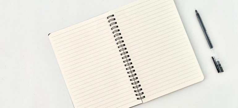 a notebook with a pen next to it