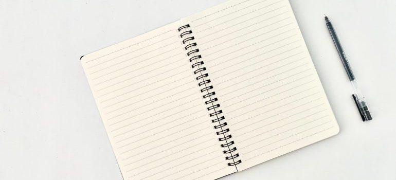 un bloc de notas con un bolígrafo junto a ella