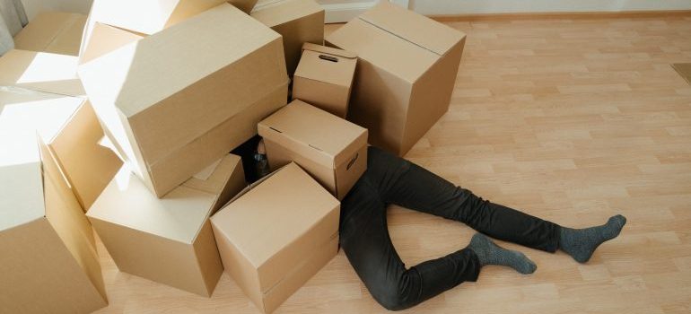 Man covered by moving boxes
