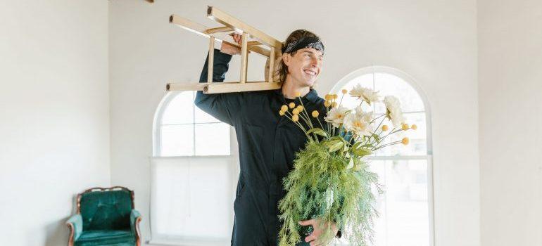 Una sonrisa y una empresa de mudanzas la realización de una planta y una silla