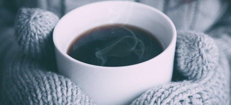 A person holding hot coffee