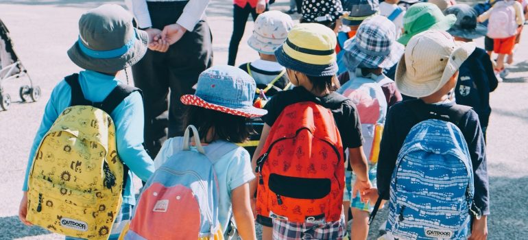 Un grupo de niños que cruza la calle con las mochilas escolares, después de que los padres se decidió acerca de Pasadena vs Boerne en movimiento. 