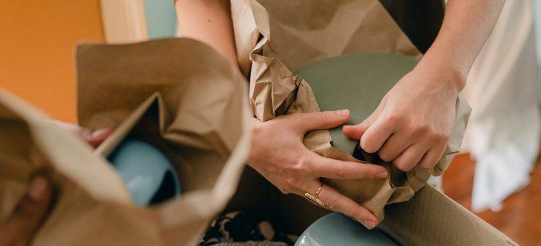 person wrapping dishes for packing