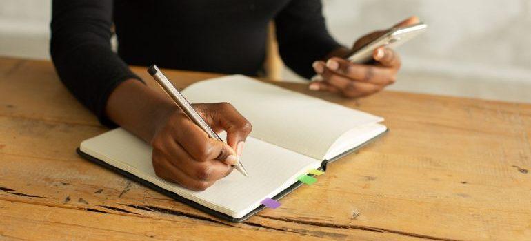 Mujer escribiendo en su cuaderno.