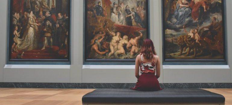 woman siting in front of three pictures