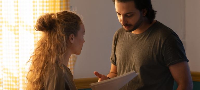 A woman and movers signing papers representing get ready for a winter move