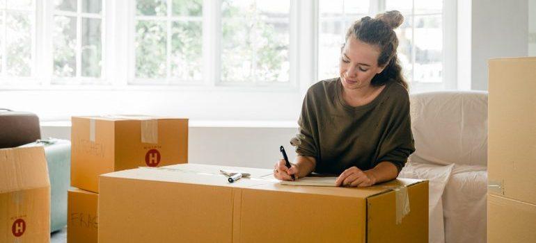 a woman packing and wondering whether she should move to Boston or Washington D.C