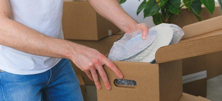 Person packing plates in a box.