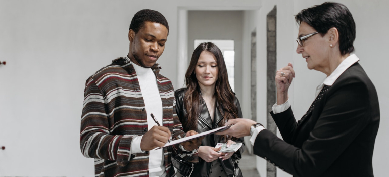 a couple signing a home purchasing deal with a realtor