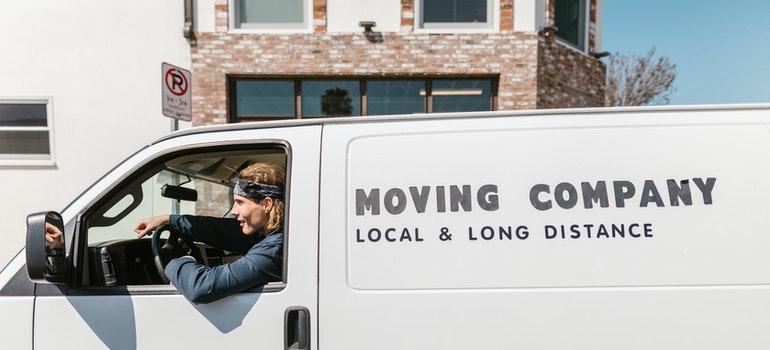 One of the long distance movers Jacinto City TX has to offer sitting in a white moving van.