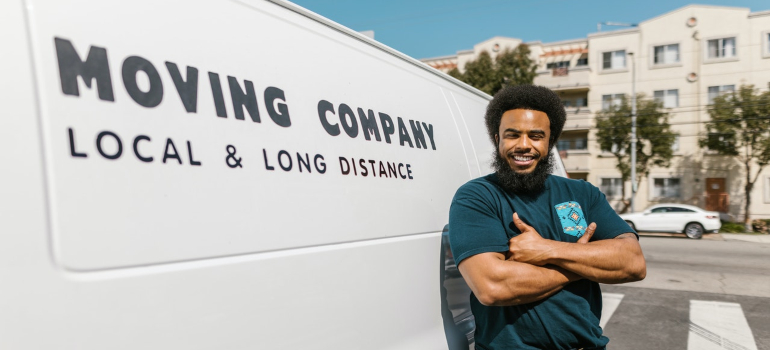 a moving company worker standing next to a moving van