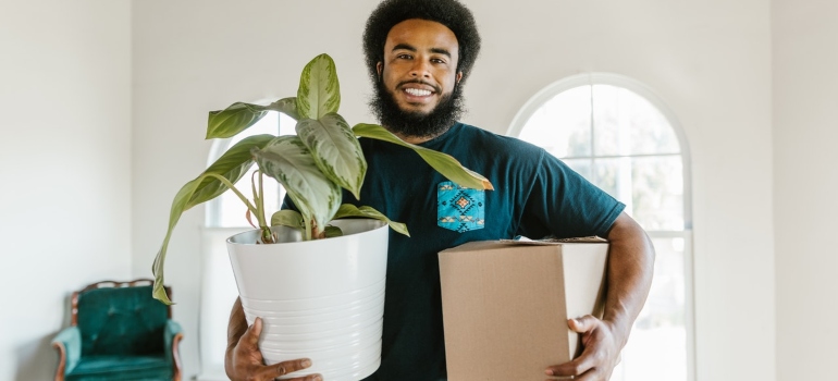 Mover carrying a pot and a box