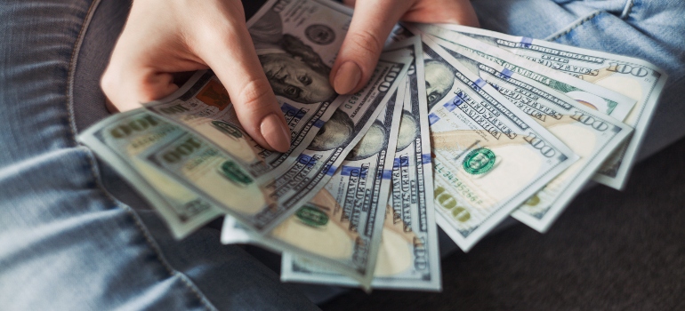 A girl counting money in order to prepare for moving from Dayton to SA