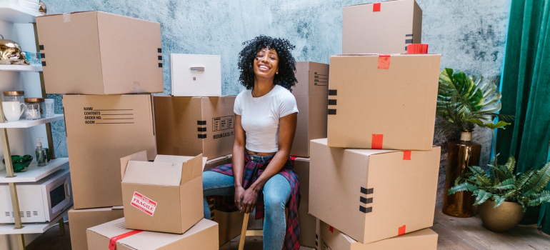 a girl sitting next to boxes